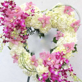 Heart-shaped floral wreath with pink orchids and white hydrangeas