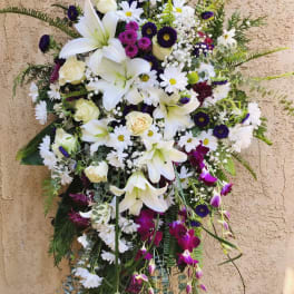 Large standing floral spray with white lilies, daisies, and purple accents