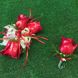 Red rose bouquet and matching boutonniere on green turf