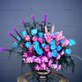 Large bouquet of blue and pink roses with pink lilies and orchids in a dark vase