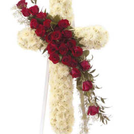 Red roses arranged on a white floral cross