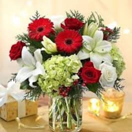 Red roses, white lilies, and red gerberas in a glass vase