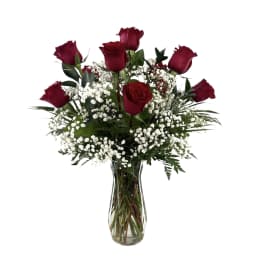 Red roses and baby's breath in a clear glass vase