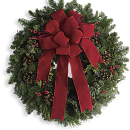 Christmas wreath with a red bow, pinecones, and red berries