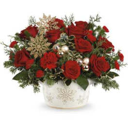 Red roses in a white snowflake vase with holiday accents