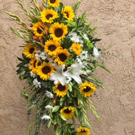 Tall floral spray with sunflowers, white lilies, and daisies