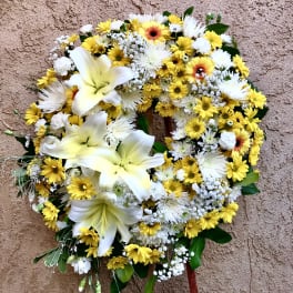 Yellow and white floral wreath on a stand