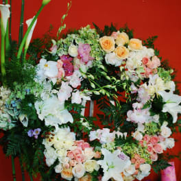 Large floral wreath with roses, orchids, lilies, and calla lilies on an easel