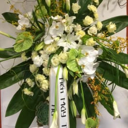 Large white floral standing spray with orchids, roses, and lilies