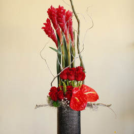 Tall red floral arrangement in a black textured vase