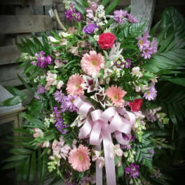 Large pink and purple floral standing spray with a ribbon bow