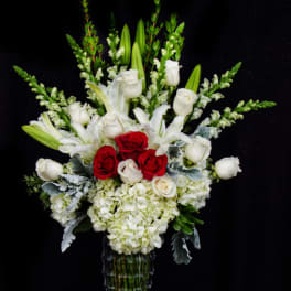 White and red floral arrangement in a clear glass vase