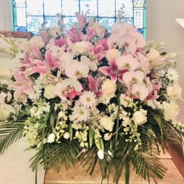 Large pink and white floral arrangement with orchids and lilies