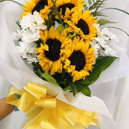Bouquet of yellow sunflowers and white daisies wrapped with a yellow ribbon