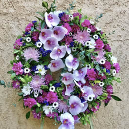 Circular floral wreath with pink orchids and mixed purple-white flowers