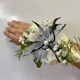 White floral wrist corsage with black ribbon and tulle