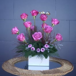 Pink roses arranged in a white box with small pink filler flowers