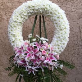 White floral funeral wreath with pink lilies and roses