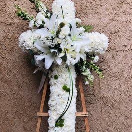 White floral cross on a wooden easel