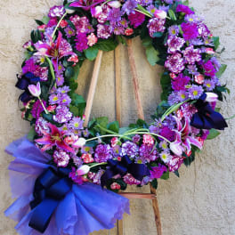 Large purple and pink floral wreath on a wooden easel