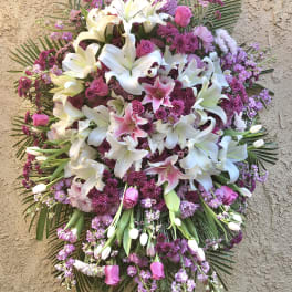 Large standing spray of white lilies and pink flowers on an easel
