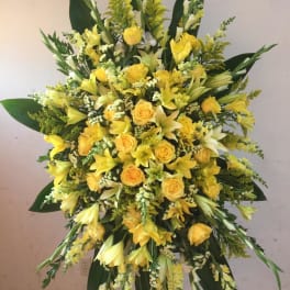 Large yellow floral standing spray with roses and lilies
