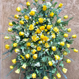Large standing spray of yellow roses with white filler flowers