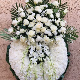 Large white funeral wreath with roses and orchids