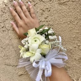 Small white wrist corsage with roses and ribbon