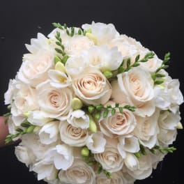 Round bouquet of white roses and white freesia with green buds