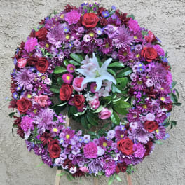 Large circular floral wreath with pink, purple, and red flowers