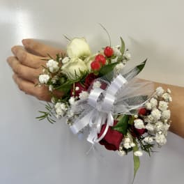 Wrist corsage with red and white roses and baby's breath