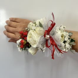 White floral wrist corsage with red ribbon and berries
