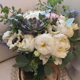 White bouquet with a succulent center and blue accents