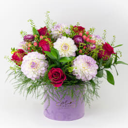 Mixed bouquet of pink and white flowers in a lavender hat box
