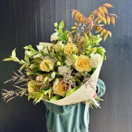 Bouquet of yellow roses and white flowers with autumn-toned foliage