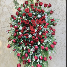 Large standing spray of red roses with white filler flowers