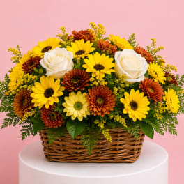 Basket arrangement of yellow daisies, orange mums, and white roses