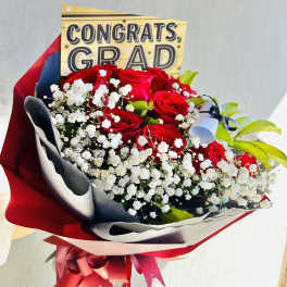 Bouquet of red roses with baby's breath and a congrats grad card