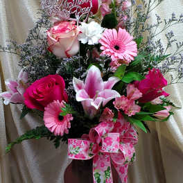 Pink and white mixed flower arrangement in a vase with a Mother's Day sign