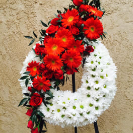 Red and white floral funeral wreath on a stand