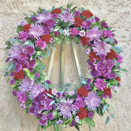 Heart-shaped floral wreath with purple, red, and pink flowers