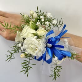 White floral wrist corsage with blue ribbon and tulle