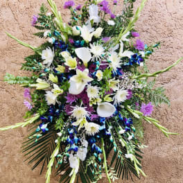 Large standing floral spray with white lilies, calla lilies, and purple blooms