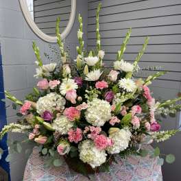 Large pink and white floral arrangement with lilies, roses, and hydrangeas