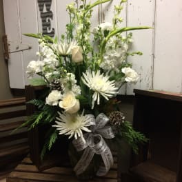 White floral arrangement with roses and daisies in a glass vase