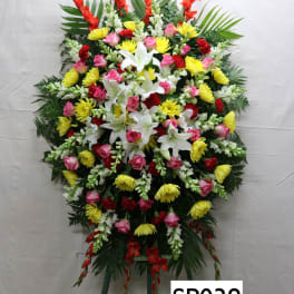 Large standing floral spray with lilies, roses, and yellow blooms