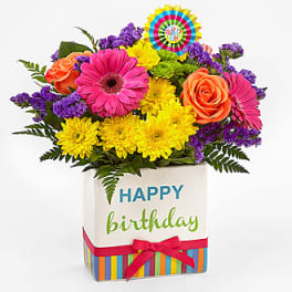 Colorful birthday flower arrangement in a gift box with a ribbon