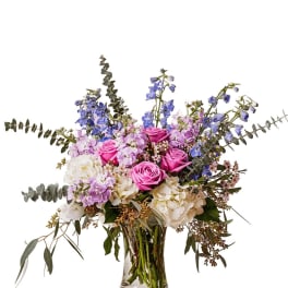 Pink roses and lavender flowers in a clear glass vase