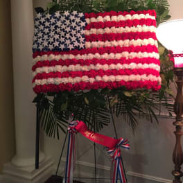 Floral American flag display on an easel with red, white, and blue flowers